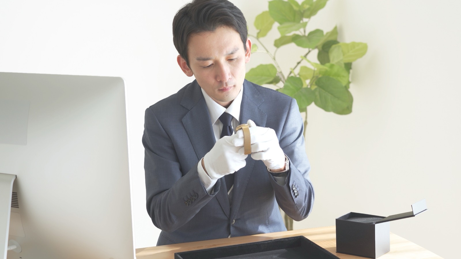 白手袋で腕時計を査定する査定員